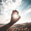 photography of sun glaring through the hole of finger